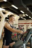 Merry young man exercising on treadmill