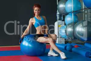 Happy athlete posing sitting on gymnastic ball