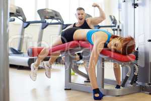 Merry man and woman tired of training in gym
