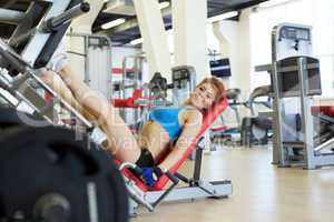 Cheerful young sportswoman exercising in gym