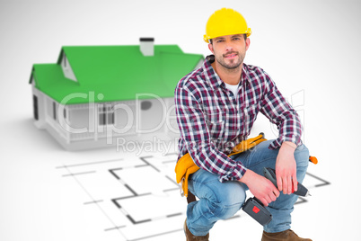 Composite image of crouching handyman holding power drill