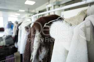 Clean clothes hanging on hangers at dry cleaner's