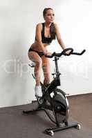 Seductive girl exercising on stationary bike