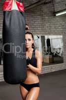 Tanned athlete looks out from behind punching bag
