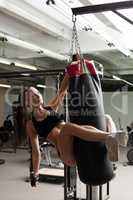 Alluring young woman posing jumped on punching bag
