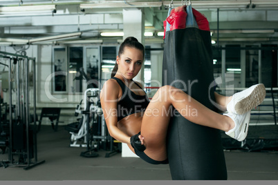 Sexy model posing jumped on punching bag