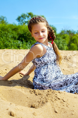 Portrait of pretty girl sitting on sand