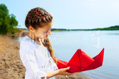 Image of lovely girl with red paper boat