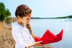 Image of lovely girl with red paper boat