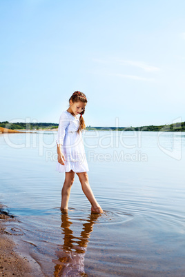 Cute little girl resting in park by lake
