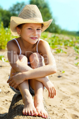 Portrait of charming young girl sitting on log