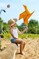 Adorable girl playing with paper windmill