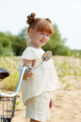 Image of amusing young girl posing with bicycle
