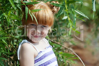 Shy red-haired girl posing with tree