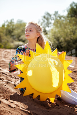 Portrait of dreamy girl posing with paper sun