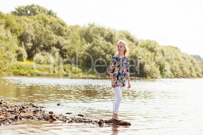 Lovely girl posing barefoot on shore of Lake