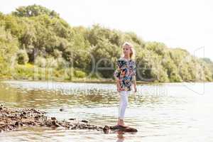 Lovely girl posing barefoot on shore of Lake