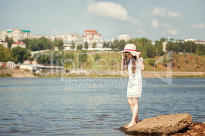 Little fashionista walks along river in park