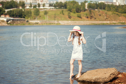 Curious little girl walking along river bank