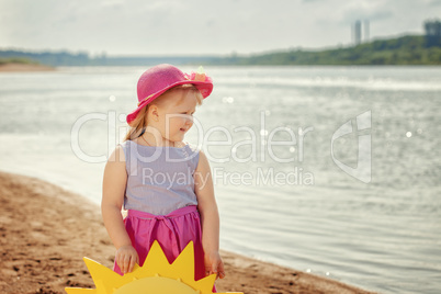Merry little girl posing on river bank, close-up