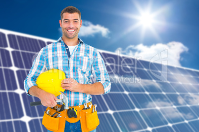 Composite image of smiling handyman holding hardhat and hammer