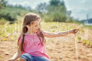 Cute little girl playing with sand in park