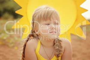 Pensive blonde girl on sun background, close-up