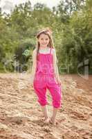 Cute little model posing in pink overall at beach