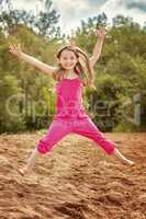 Image of cheerful girl jumping on beach