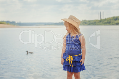 Funny blonde girl posing on background of lake