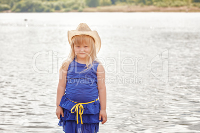 Smiling little model posing by lake