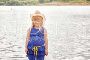 Smiling little model posing by lake