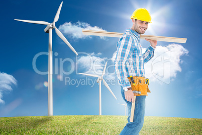 Composite image of smiling worker carrying wooden planks