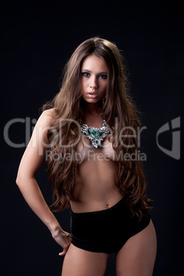Cute busty girl with long hair posing in necklace