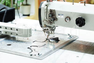 Machine sews parts of shoes, close-up