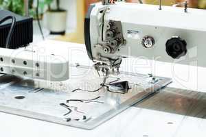Machine sews parts of shoes, close-up