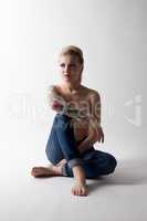 Tattooed model posing topless in jeans