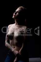 Sensual tattooed model posing topless