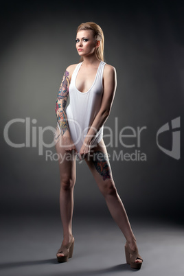 Studio shot of leggy tattooed girl