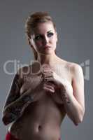 Image of topless tattooed woman posing in studio
