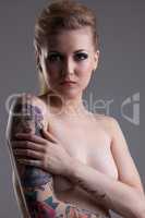 Curvy tattooed woman posing topless