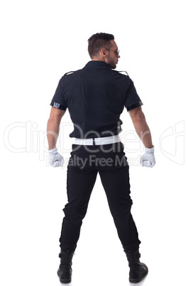 Fashionable muscular cop posing back to camera
