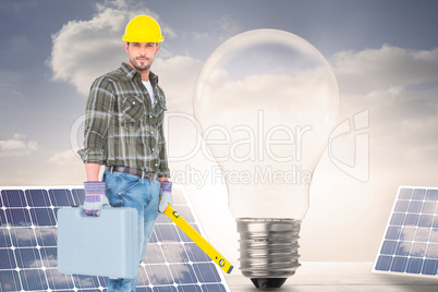 Composite image of manual worker with spirit level and toolbox