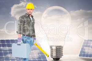 Composite image of manual worker with spirit level and toolbox