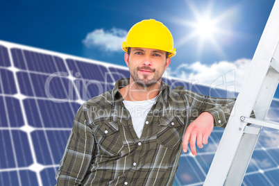 Composite image of smiling handyman in overalls leaning on ladde