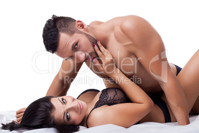 Beautiful lovers in bed posing at camera