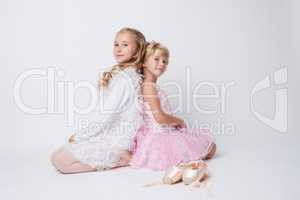 Blonde sisters posing with pointes in studio