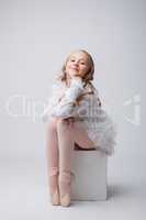 Coquettish little ballerina posing at camera