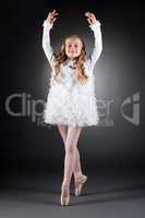 Smiling curly-haired girl dancing on pointes