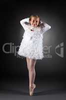 Little ballet dancer posing in white dress